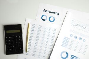 calculadora com alguns papeis e graficos representado a regra 50-30-20
