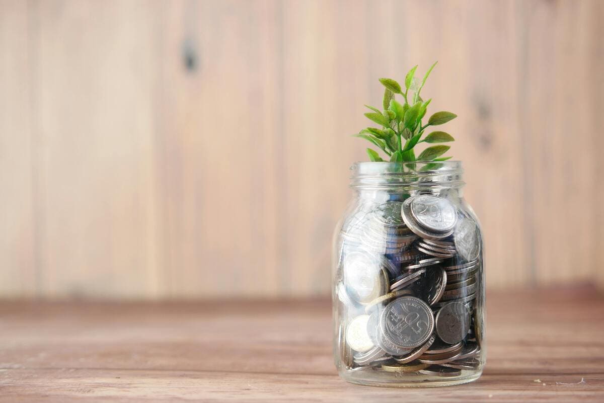 pote de vidro com moedas, onde está guardado a reserva de emergência.